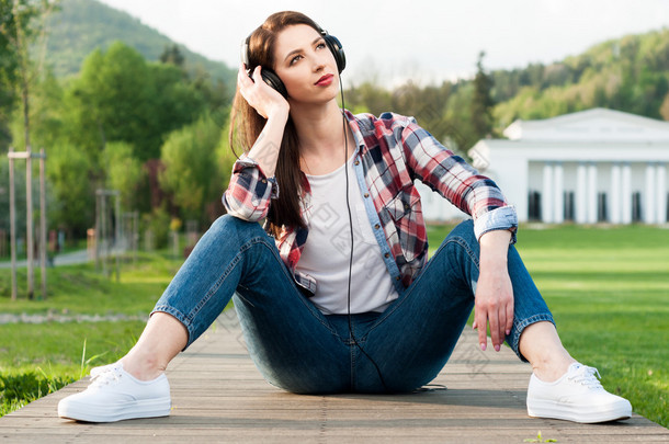 年轻漂亮的女人，戴着耳机听音乐的图片