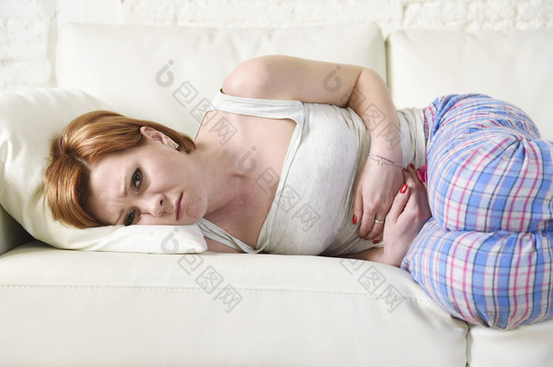 woman with hands on her belly or tummy suffering stomach cramp and period pain