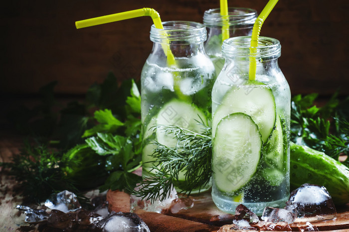 Refreshing cold drink of cucumber and herbs in glass bottles