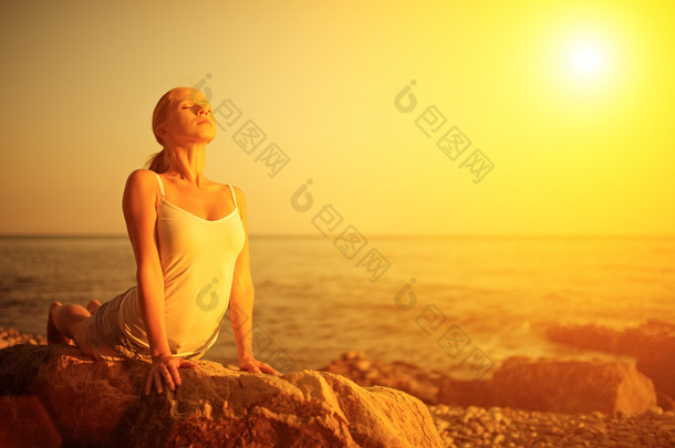 在日落时分做<strong>瑜伽</strong>在海滩上的女人