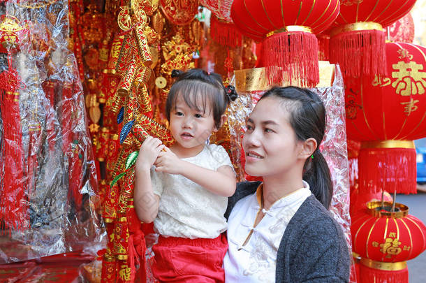 中国<strong>农历</strong>新年春<strong>节</strong>在唐人街在曼谷，泰国亚洲女人和她的女儿在中国服饰对传统中国红装饰是很受欢迎.
