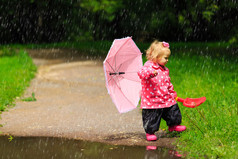 可爱的小女孩，用雨伞雨衣和雨鞋