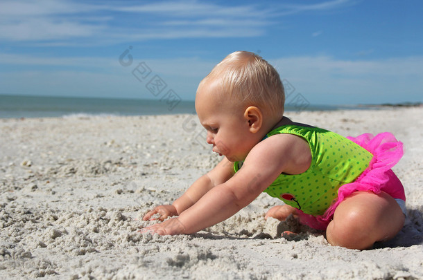 可爱的小宝贝<strong>女孩</strong>玩在沙滩上的沙子