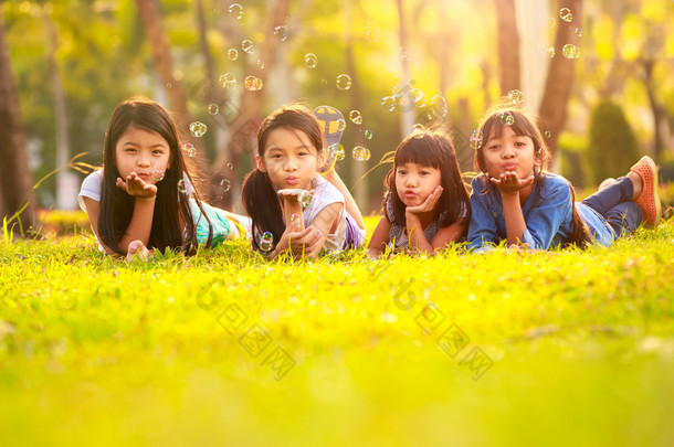 可爱的孩子在公园的<strong>绿草坪</strong>上尽情的泡沫