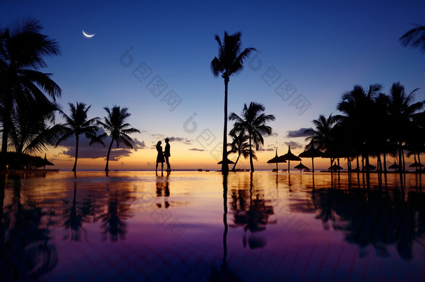 年轻的夫妇在风景秀丽的日落时的剪影
