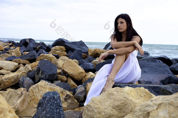 悲伤的女人，坐在岩石站海洋