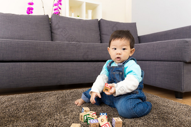 亚洲小男孩玩玩具块在家里