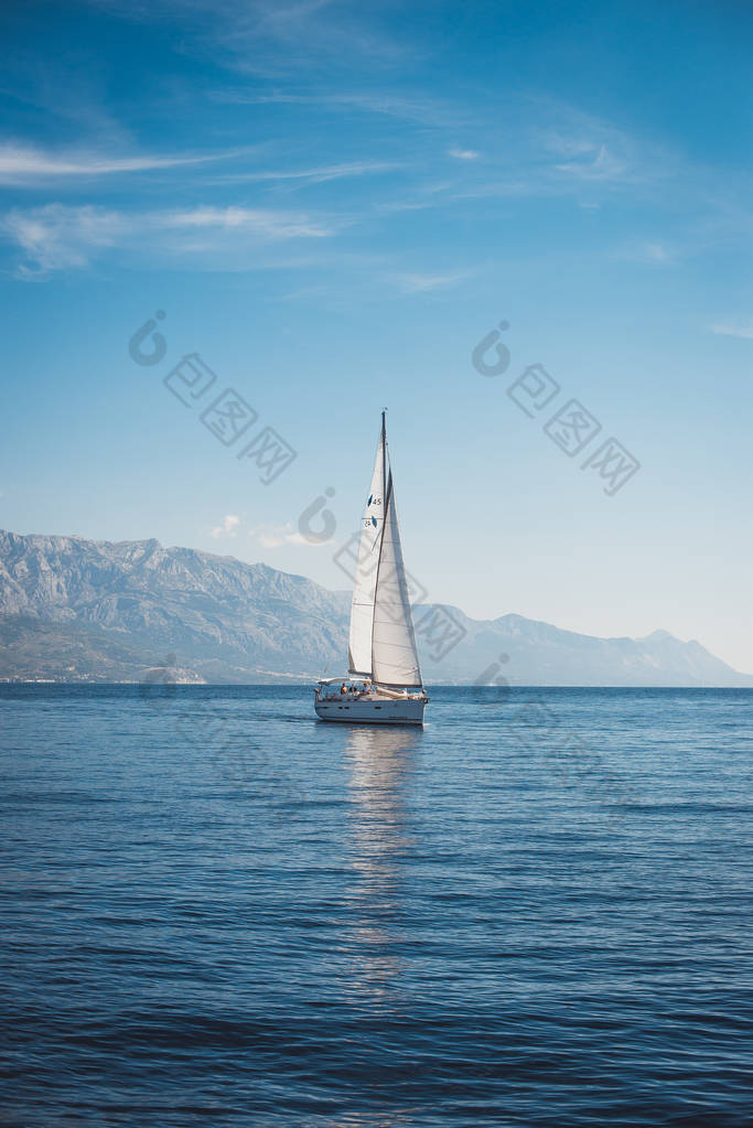 在高山背景下的海面上航行的游艇