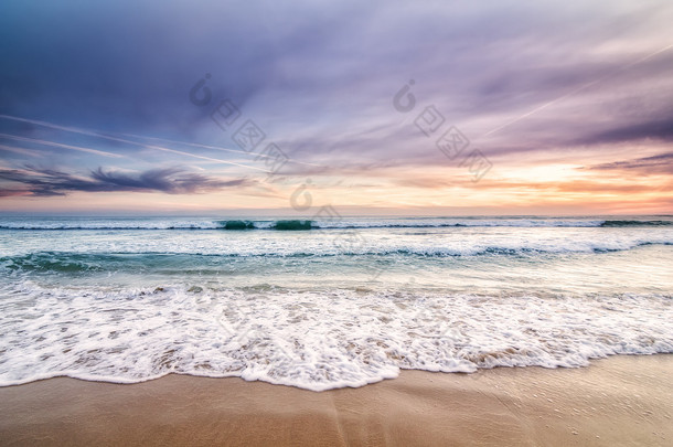 波浪和日落海滩上的沙