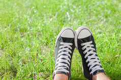 在绿色草地上运动鞋的双脚