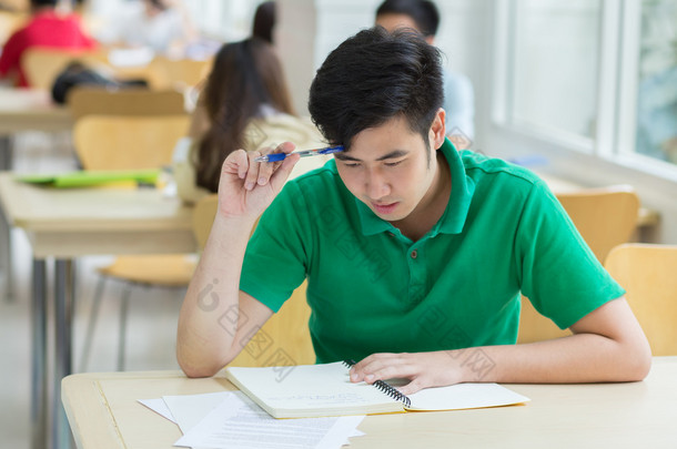 亚洲学生在图书馆工作.