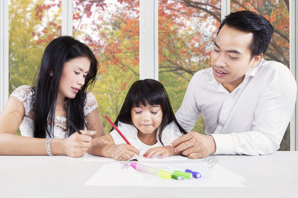 Creative child studying with parents at home