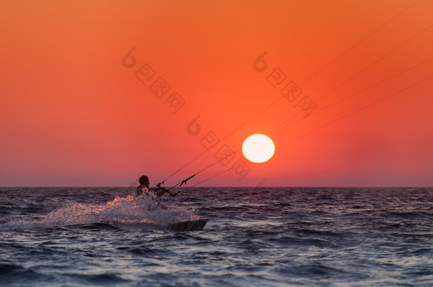 航行在日落时的 kitesurfer 的剪影