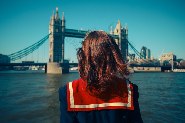 在伦敦塔桥上看船上的年轻女子