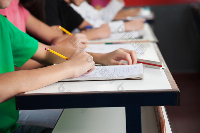 高中学生在桌在纸张上书写 小学,教室上课,中小学生