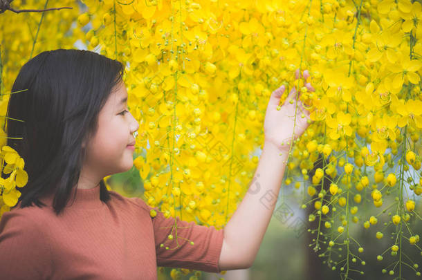  亚洲女孩与金雨树我