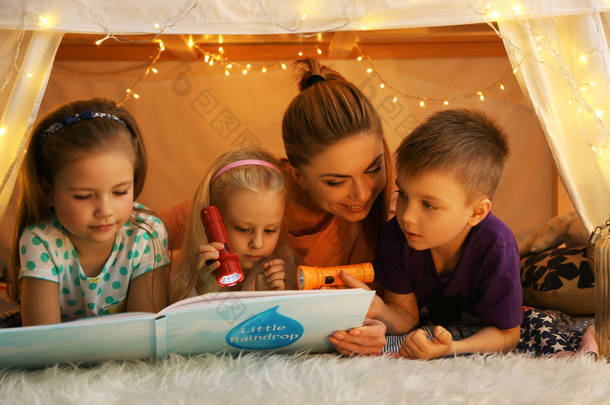小女孩和逗人喜爱的孩子读书在<strong>小屋</strong>在家