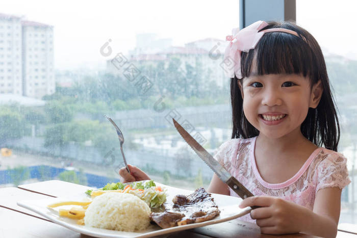 微笑亚洲中国小女孩吃羊肉牛肉饭