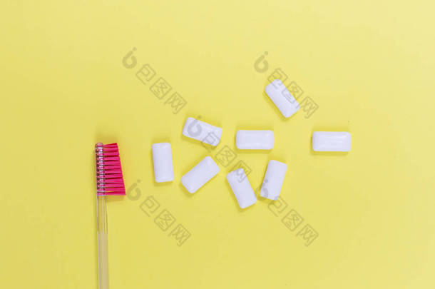 用口香糖代替隔离在黄色背景上的牙刷