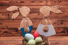 几个站在鸡蛋篮子附近的木制复活节兔子