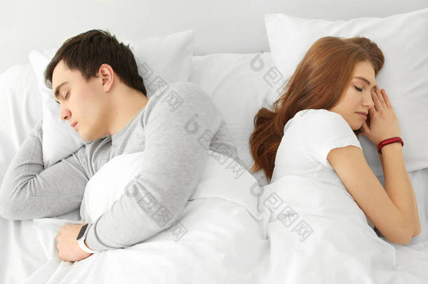 对年轻情侣在家里的床上休息的睡眠跟踪器