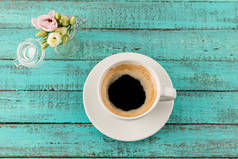 咖啡杯子蒸汽和桌上的花
