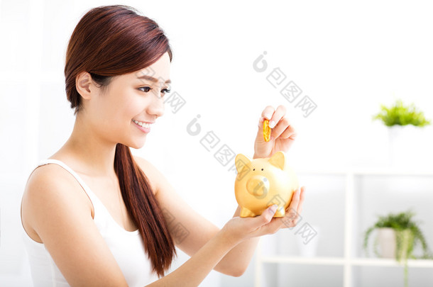 幸福的年轻女人在储钱罐存钱