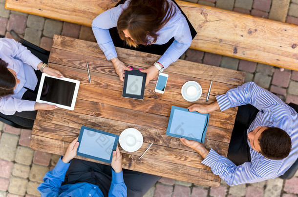 Business people with Digital Devices at cafe Table