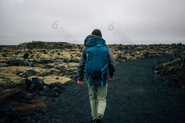 年轻人在崎岖的冰岛地形中徒步