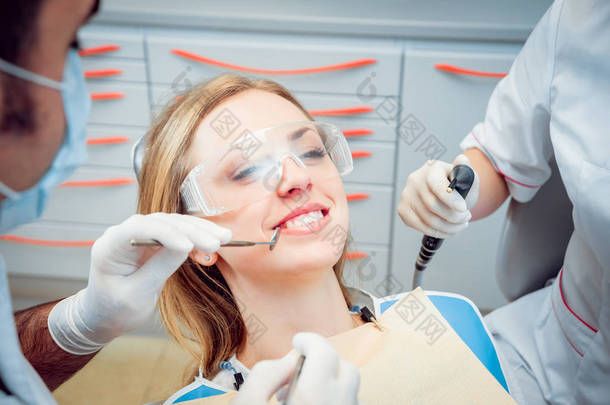 <strong>年轻的女人微笑</strong>着看牙医。医疗设备