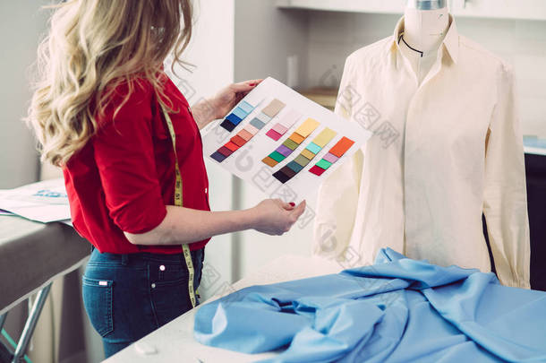 量身定制的妇女选择颜色从调色板的新衬衫在<strong>工作室</strong>