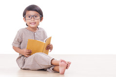 可爱的男孩正在读一本书，戴着眼镜