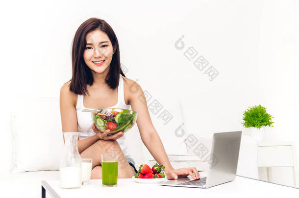 快乐的女人吃, 并显示健康新鲜沙拉在碗里。