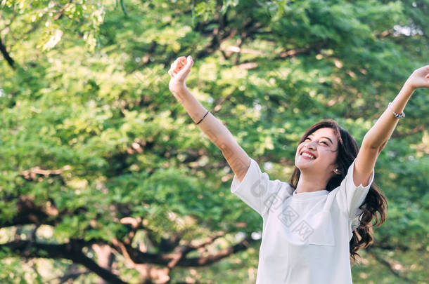 妇女<strong>站立</strong>舒展她的胳膊放松和享用自然新鲜空气