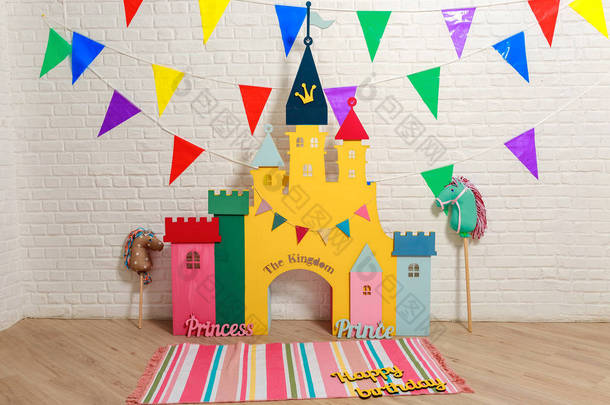 <strong>玩具</strong>城堡背景的照片拍摄的生日。 为孩子们的生日庆祝活动贴上装饰品的照片区. 儿童摄影工作室为儿童。 纸板箱色彩艳丽的儿童城堡