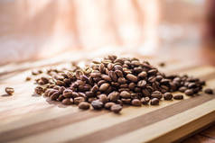 烤阿拉伯咖啡豆散落在木板上.
