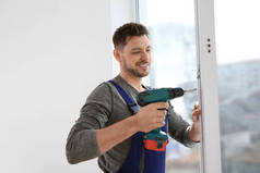 施工工人在室内安装窗户时使用钻头
