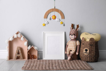 婴儿房墙边的空相框和可爱的玩具。室内设计图片