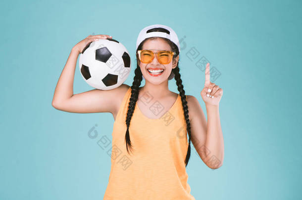 球迷体育妇女<strong>微笑</strong>和快乐, 拿着一个足球, 庆祝点一手指向上优胜者标志