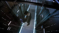 顶视图通过它的玻璃与在数据中心中的笔记本电脑工作的工程师，充满了活跃的机架式服务器.