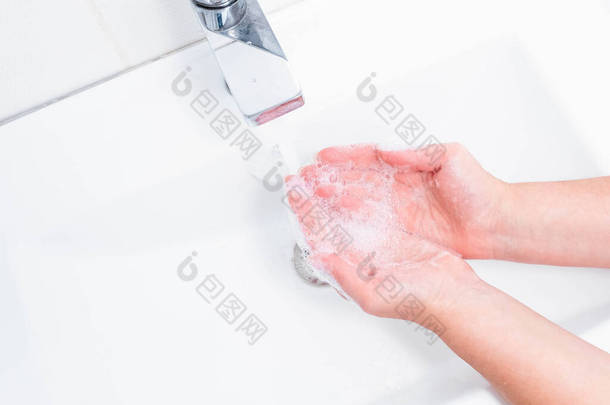 用人的肥皂和水洗手以防止考拉韦病毒，卫生以防止考拉韦病毒的<strong>传播</strong>。女人用肥皂在水龙头下洗手。手部卫生概念细节.