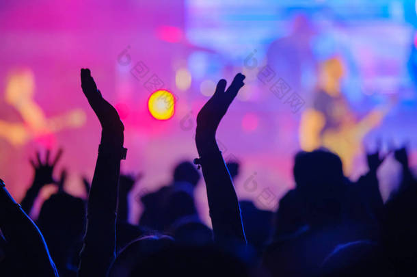 现场摇滚音乐会的歌迷在舞台上为音乐家加油