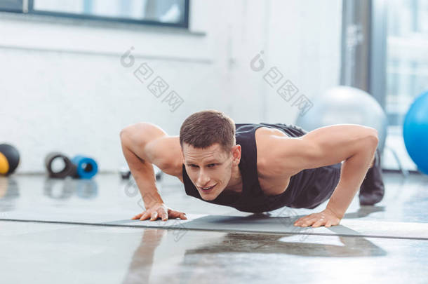 年轻运动员做俯卧撑瑜伽垫 