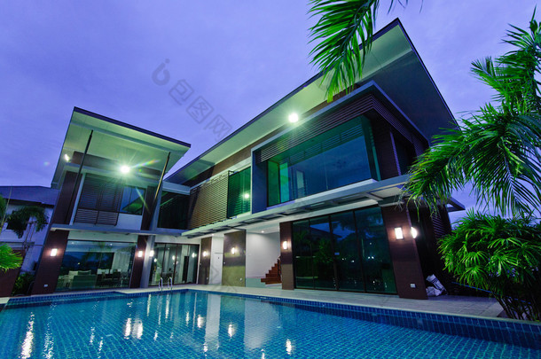 现代的房子，有室外游泳池，在夜间 