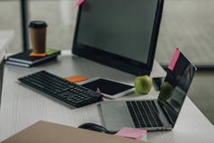 办公桌，笔记本电脑，电脑显示器，键盘和数字平板电脑在办公室