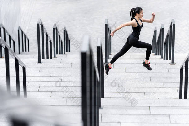 女运动员训练对体育场楼梯 