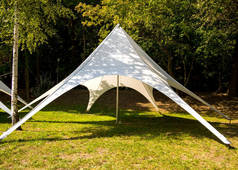轻质织物制成的帐篷矗立在一个空地上