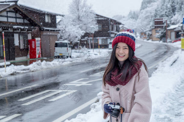 在白川乡村庄地区的快乐女孩在冬季下雪, 与传统的房子 gassho 风格和联合国教科文组织世界遗产之一, 岐阜县, 日本