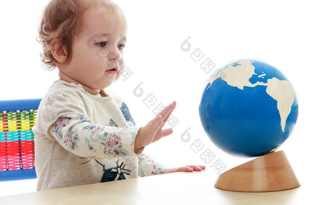 非常小，但是严重的小女孩，旋转地球仪手.