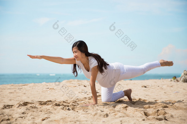 亚洲孕妇做瑜伽在大海的岸边